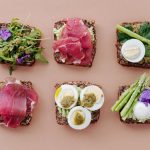 A top view of gourmet sandwiches with fresh ingredients presented in a flat lay style.